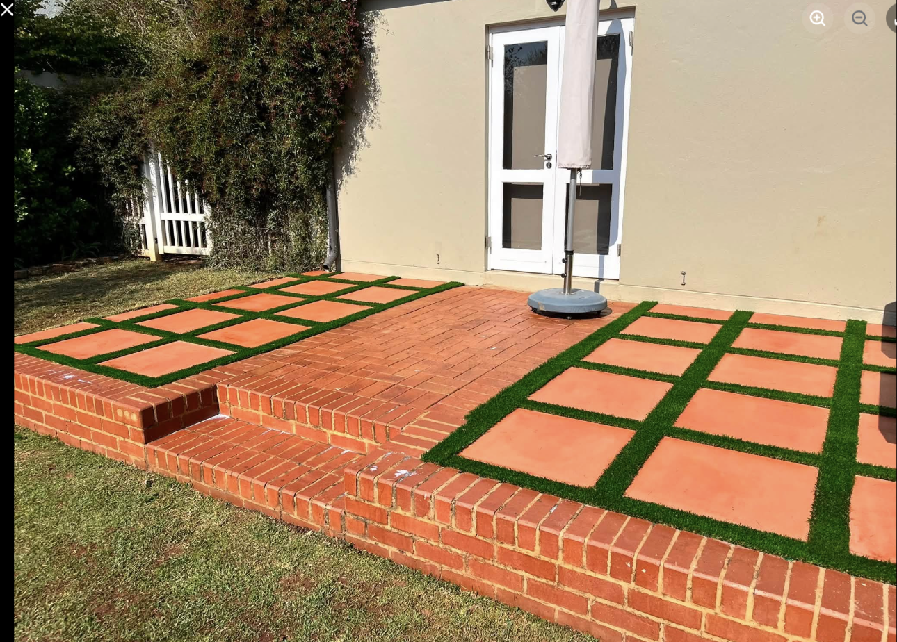 Terracotta slab patio with artificial grass inlay at Southdowns Estate, Irene