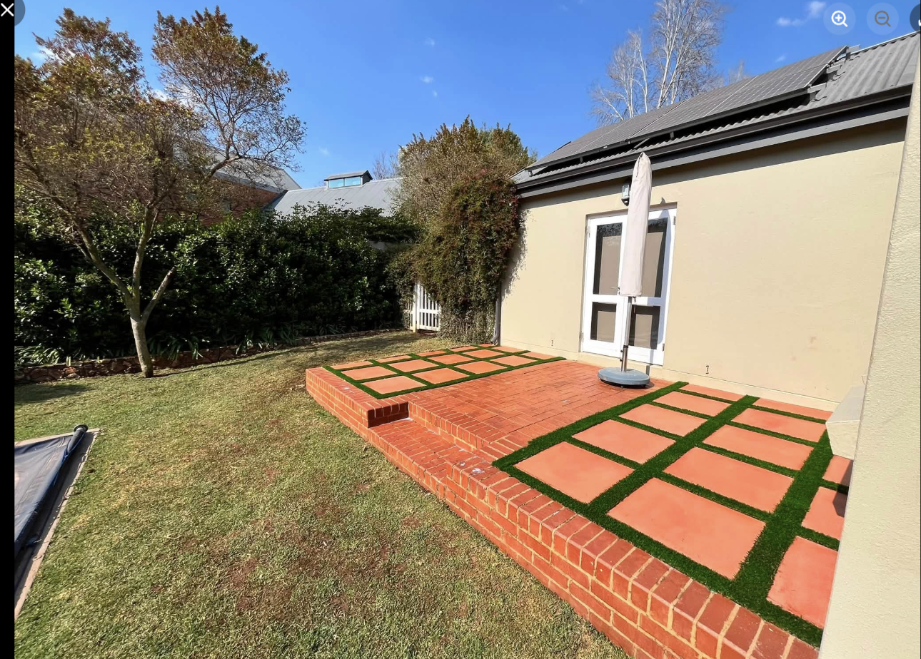 Terracotta slab patio with artificial grass inlay — Southdowns Estate, Irene